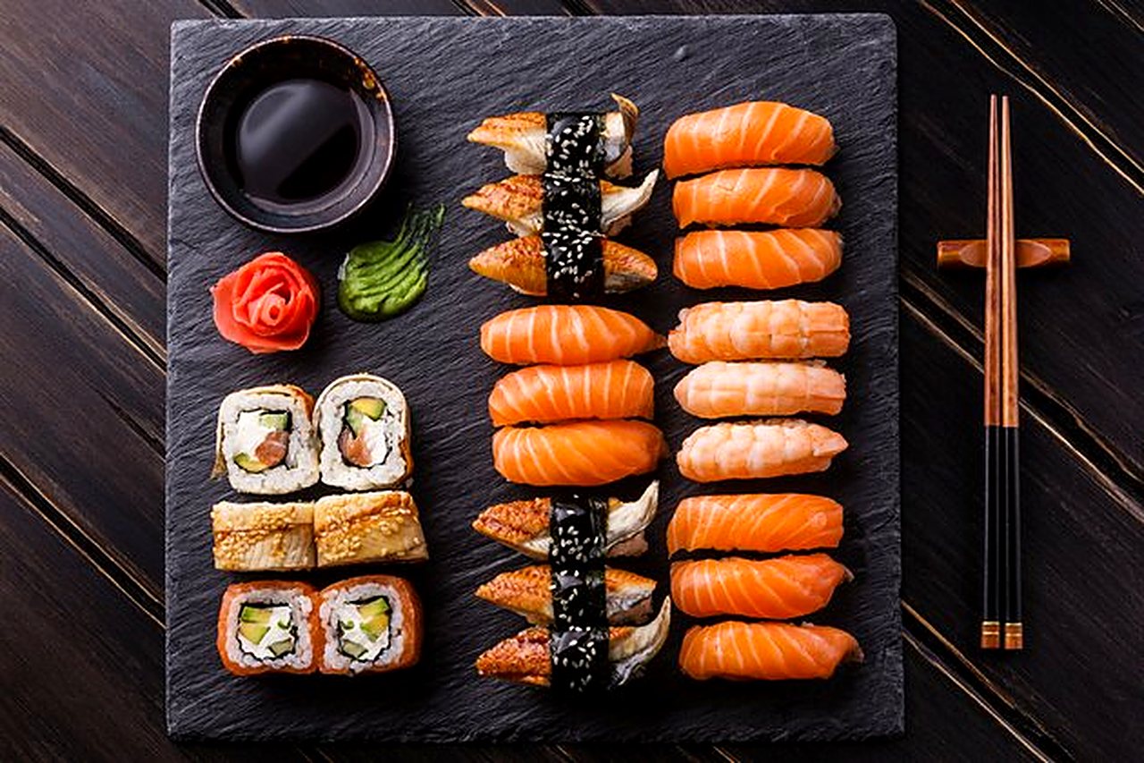 Salmon nigiri and rolls on a slate board